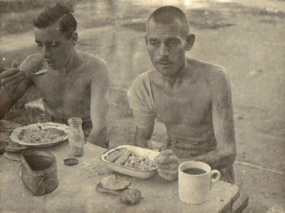 Changi. Men of the Loyal North Lancashire Regt, enjoy their meal of rice stew and 'Dourers' Oct. 1942-tn